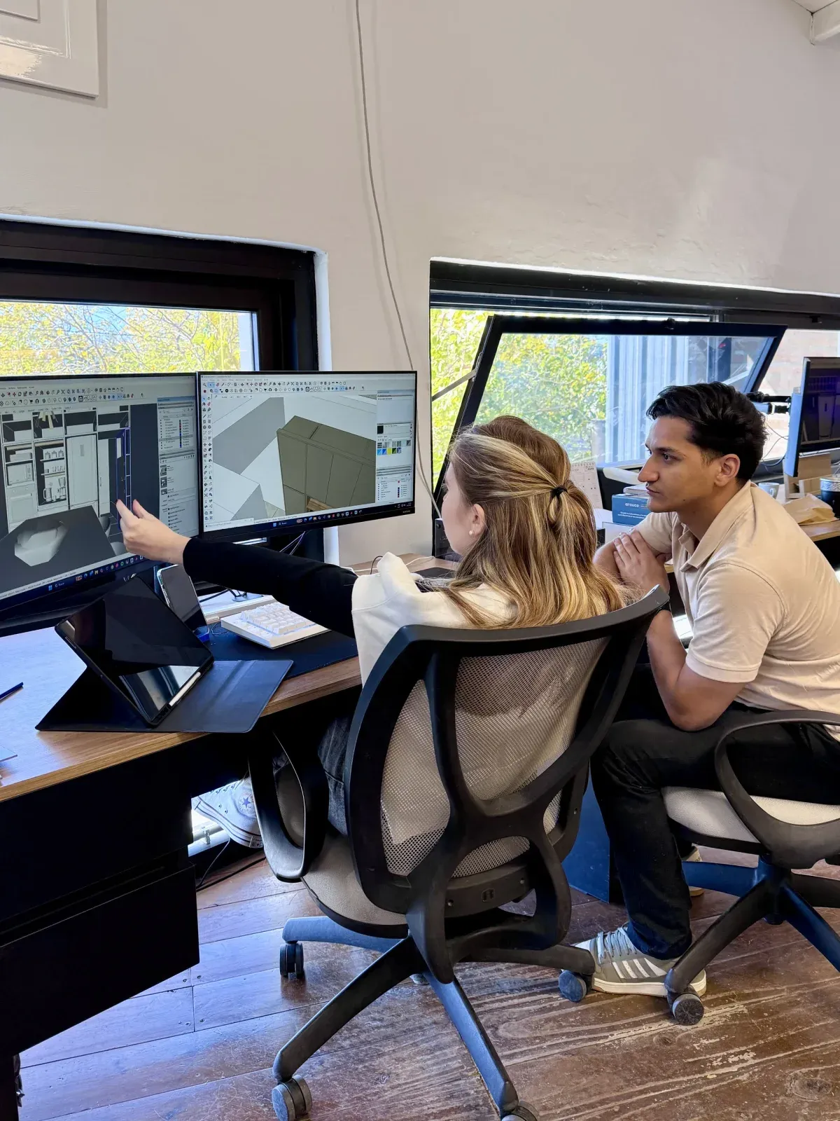 Dos diseñadores de Brothers revisan el modelo 3D de un mueble en la computadora