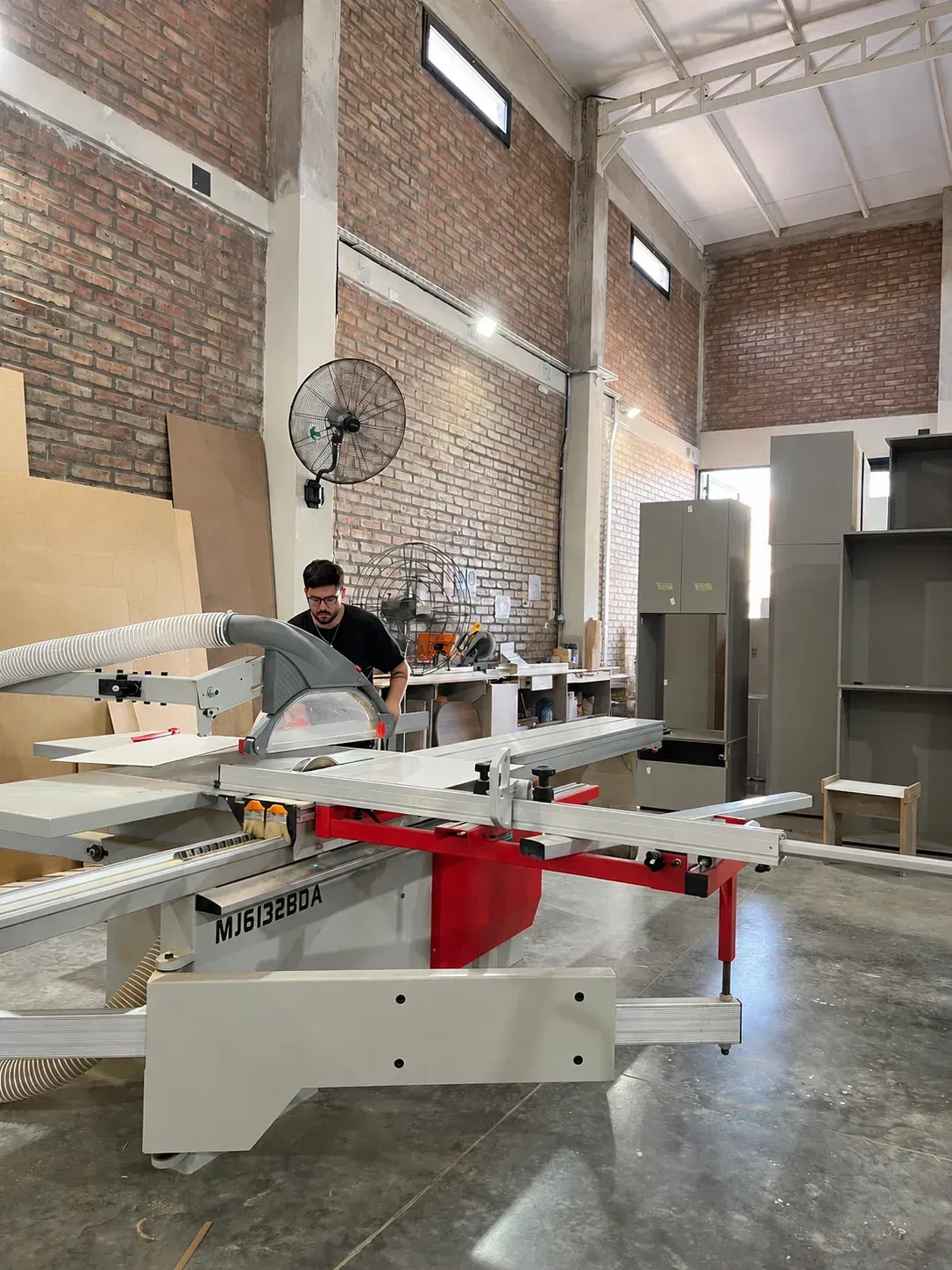 Integrante de Brothers en la escuadradora, cortando placas en el taller
